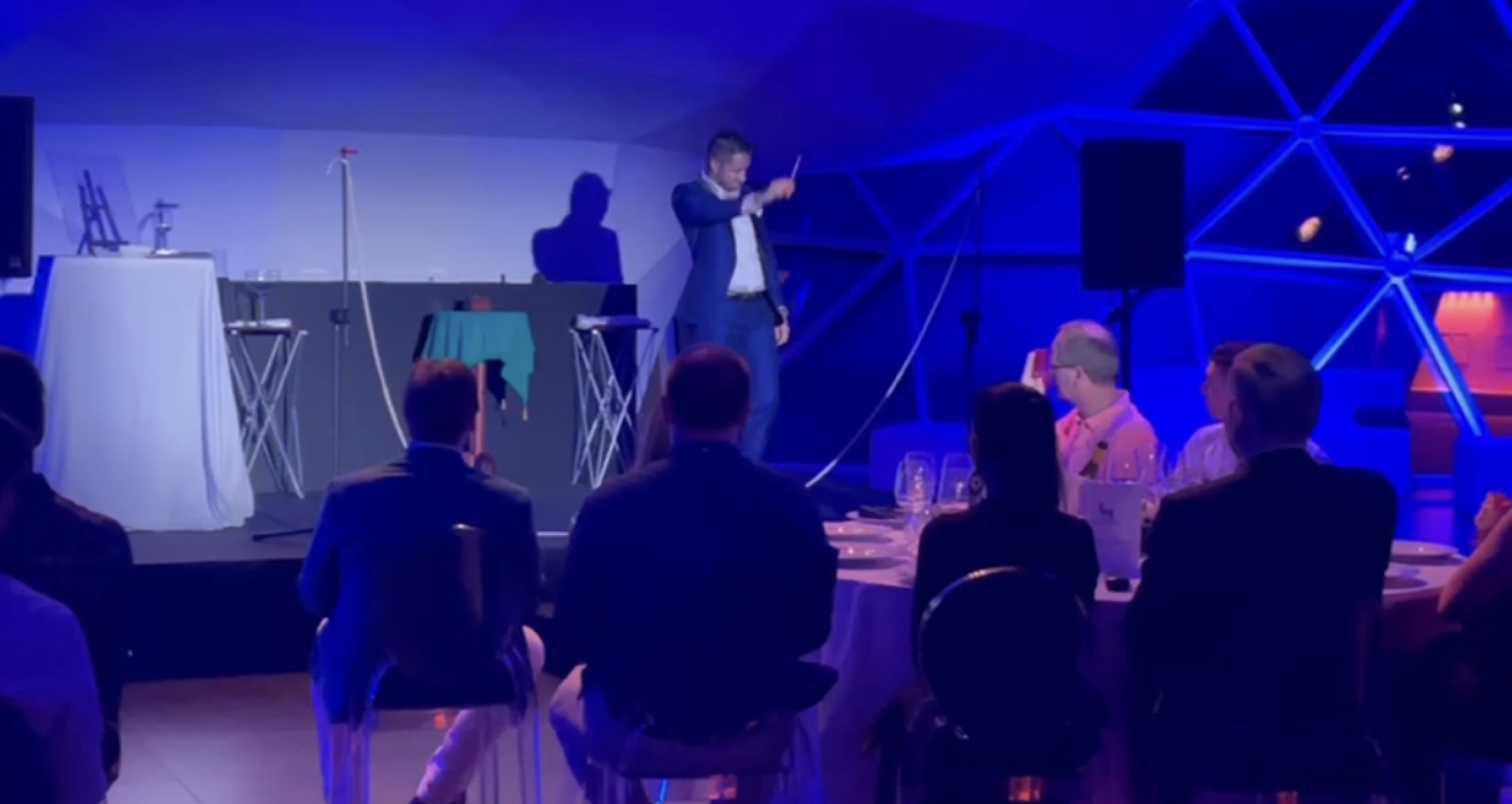 Nikola Previti si esibisce durante un evento aziendale con illuminazione blu scenografica