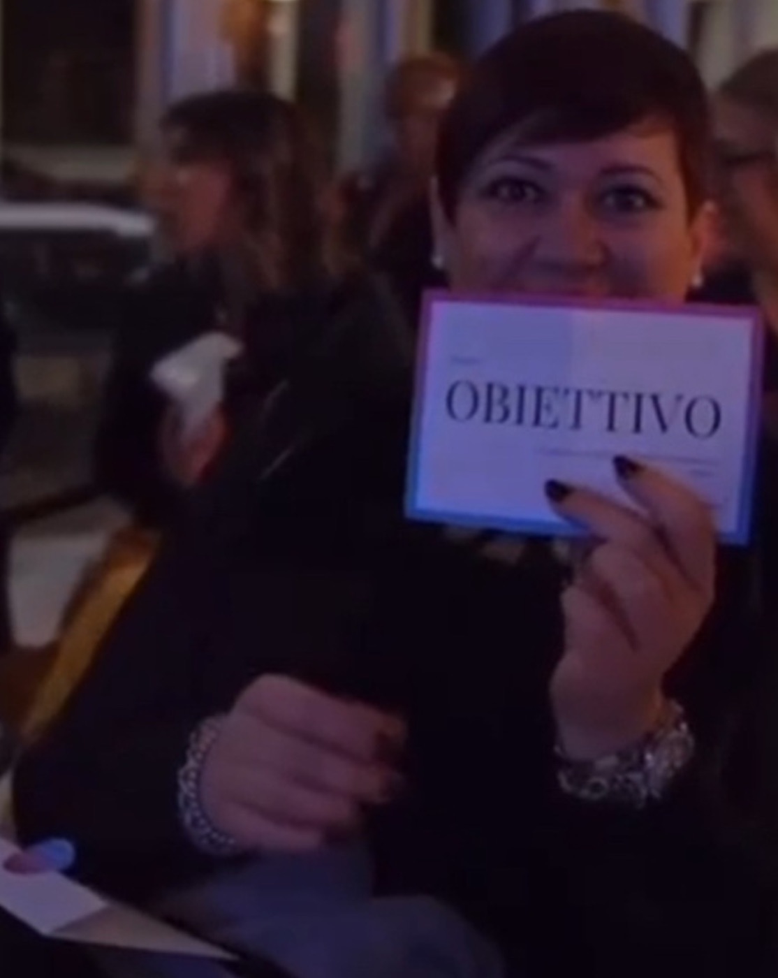 Partecipante mostra la carta Obiettivo durante un intervento motivazionale di Nikola Previti